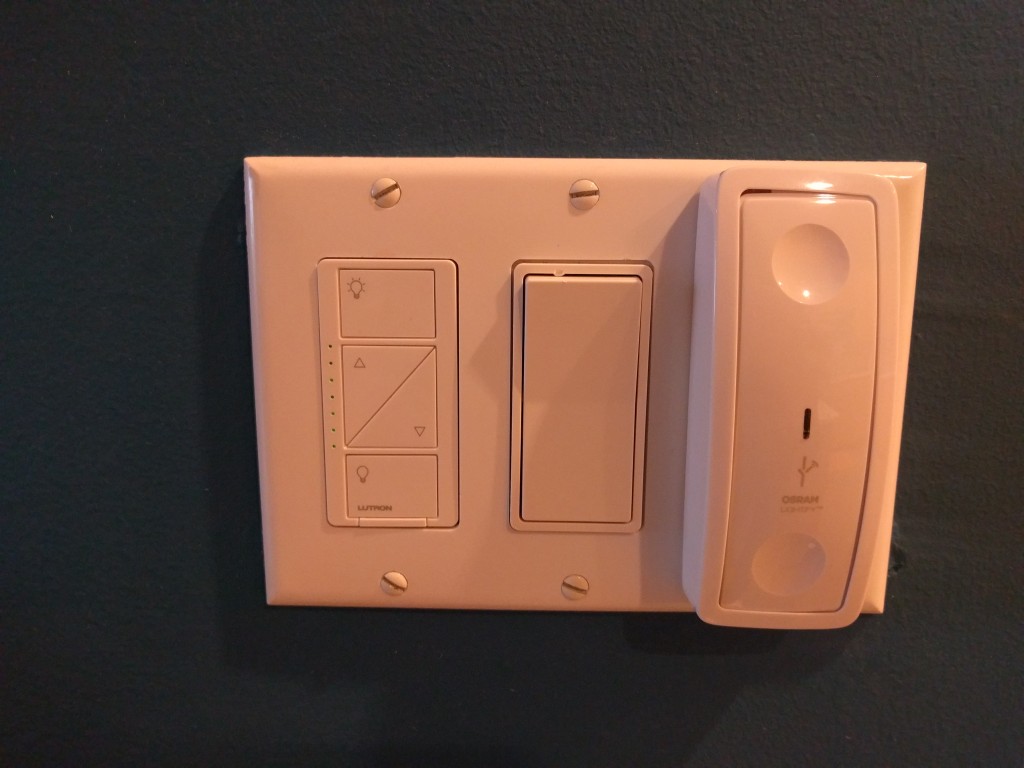 A Lutron Caseta dimmer switch (left) installed near the Osram Lightify wireless dimmer switch (right). A regular rocker switch is in the middle.